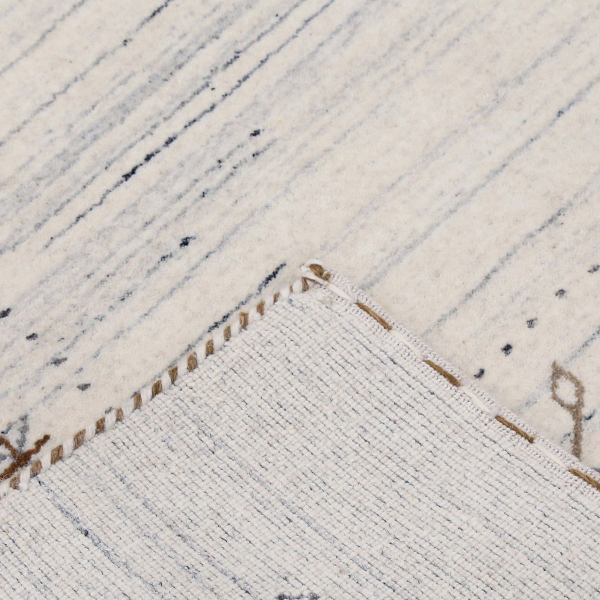 Corner and edge detail of ivory Hand Woven Loom Lori wool rug showing zigzag border and handcrafted finishing