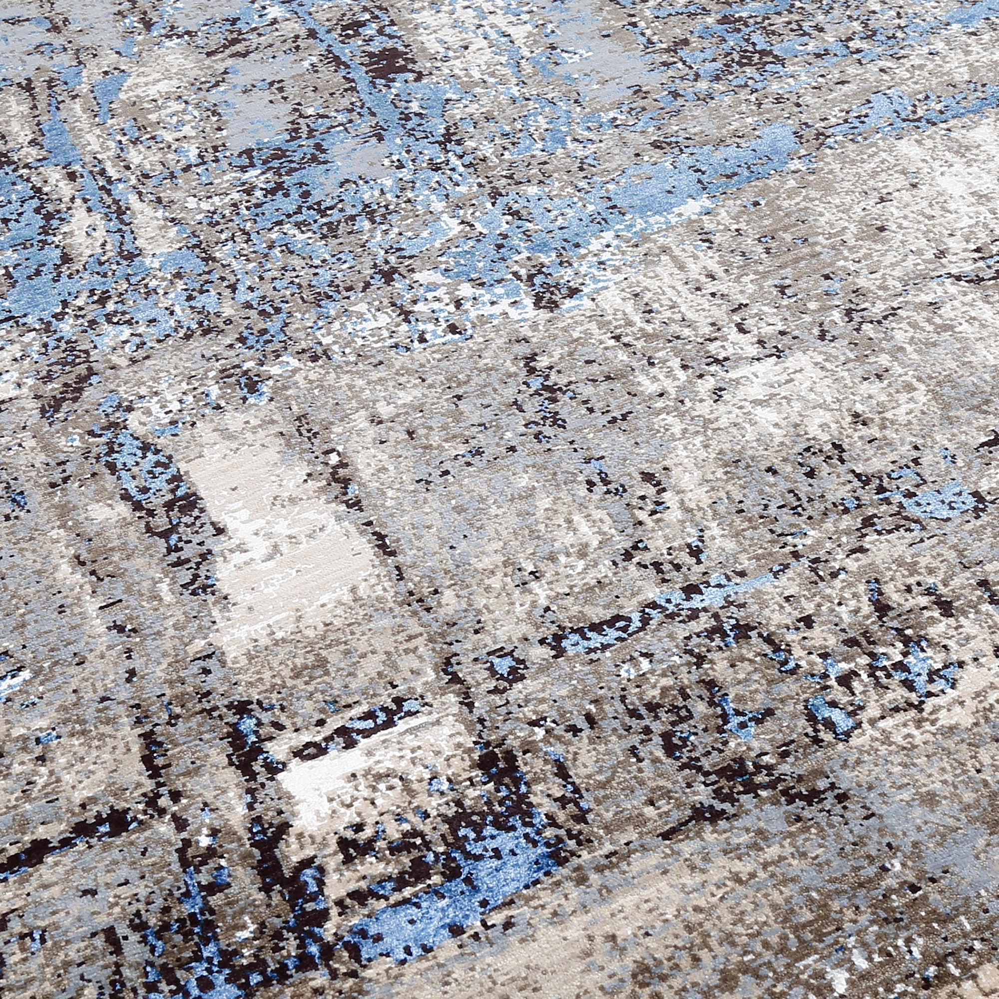 Close-up of the hand knotted wool and viscose texture with beige grey brown and sky blue abstract detailing