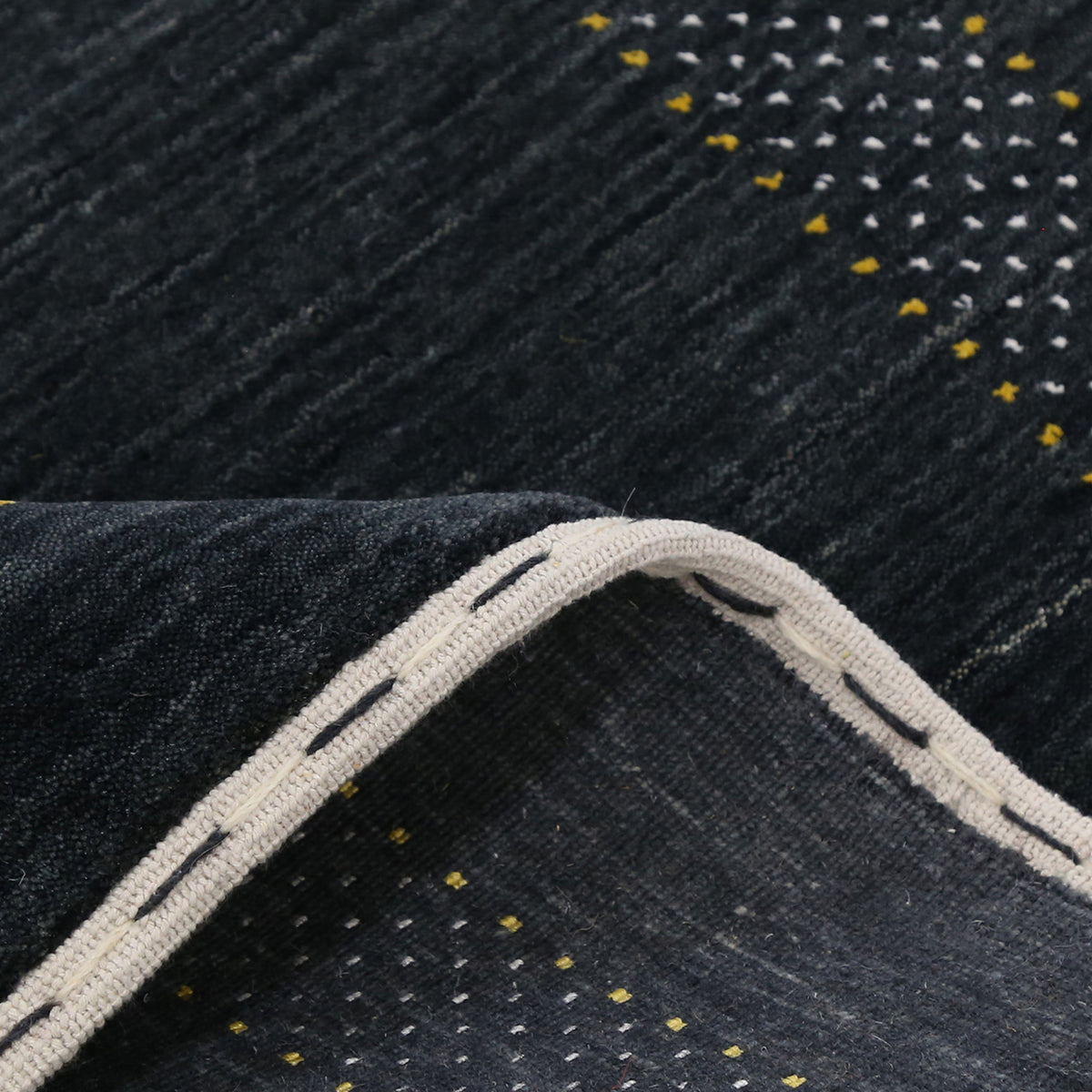 Close-up texture of black Hand Woven Loom Lori wool rug showing natural wool fibres and intricate tribal motif details