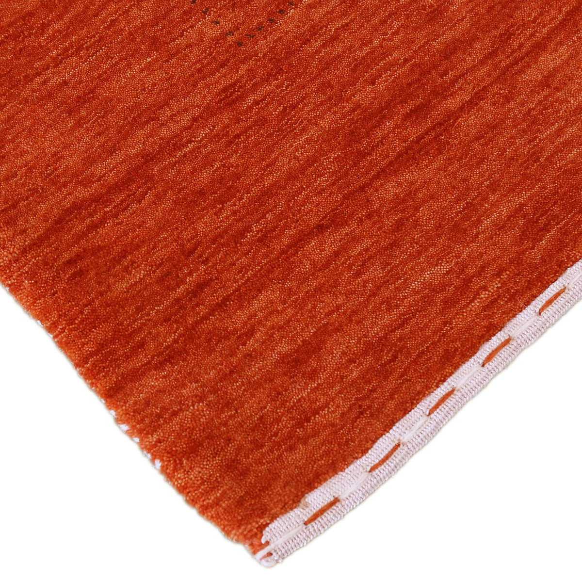 Corner and edge detail of burnt orange Hand Woven Loom Lori wool rug showing natural wool texture and handcrafted finishing