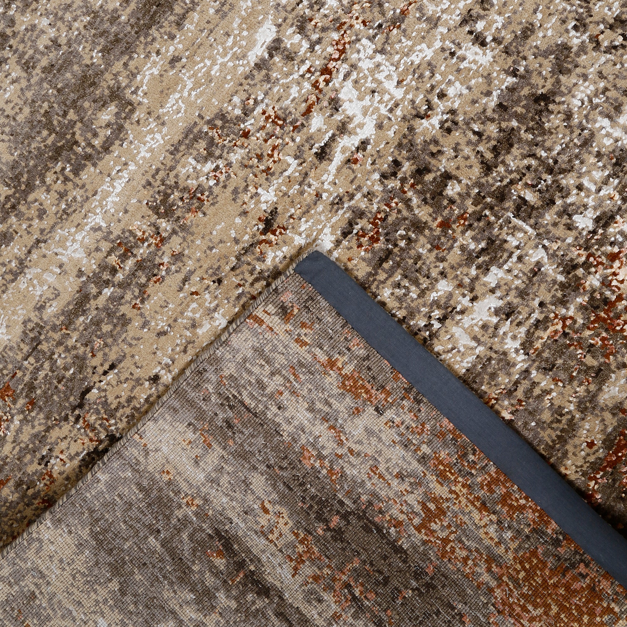 Hand-finished edge and layered distressed surface of the Copper Drift hand knotted modern rug