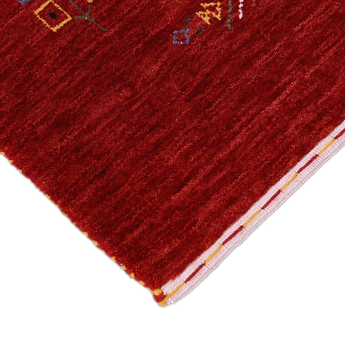 Corner and edge detail of deep red Hand Woven Loom Lori wool rug showing handcrafted finish and tribal pattern details