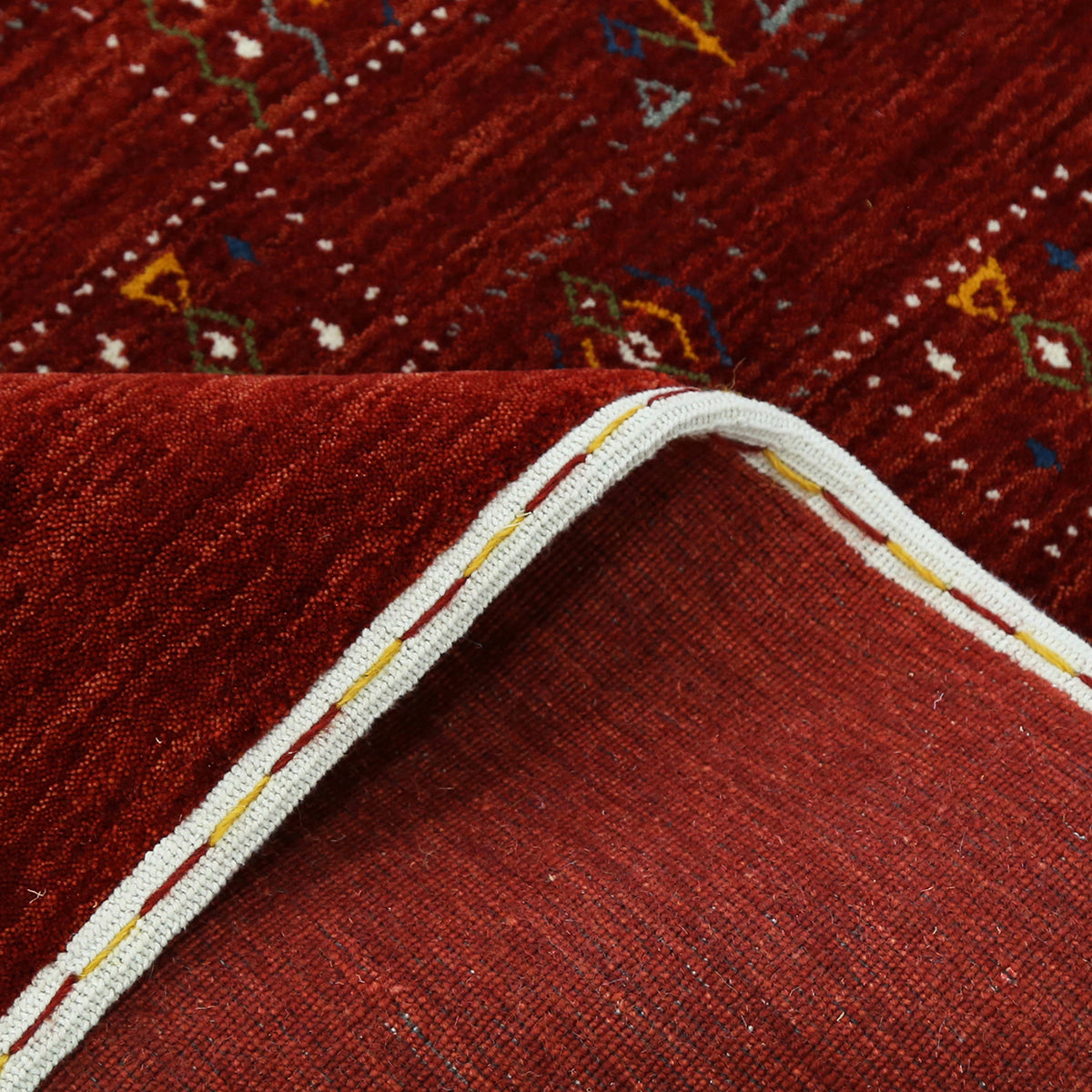 Corner and edge detail of crimson red Hand Woven Loom Lori wool rug showing rich wool texture and handcrafted finishing