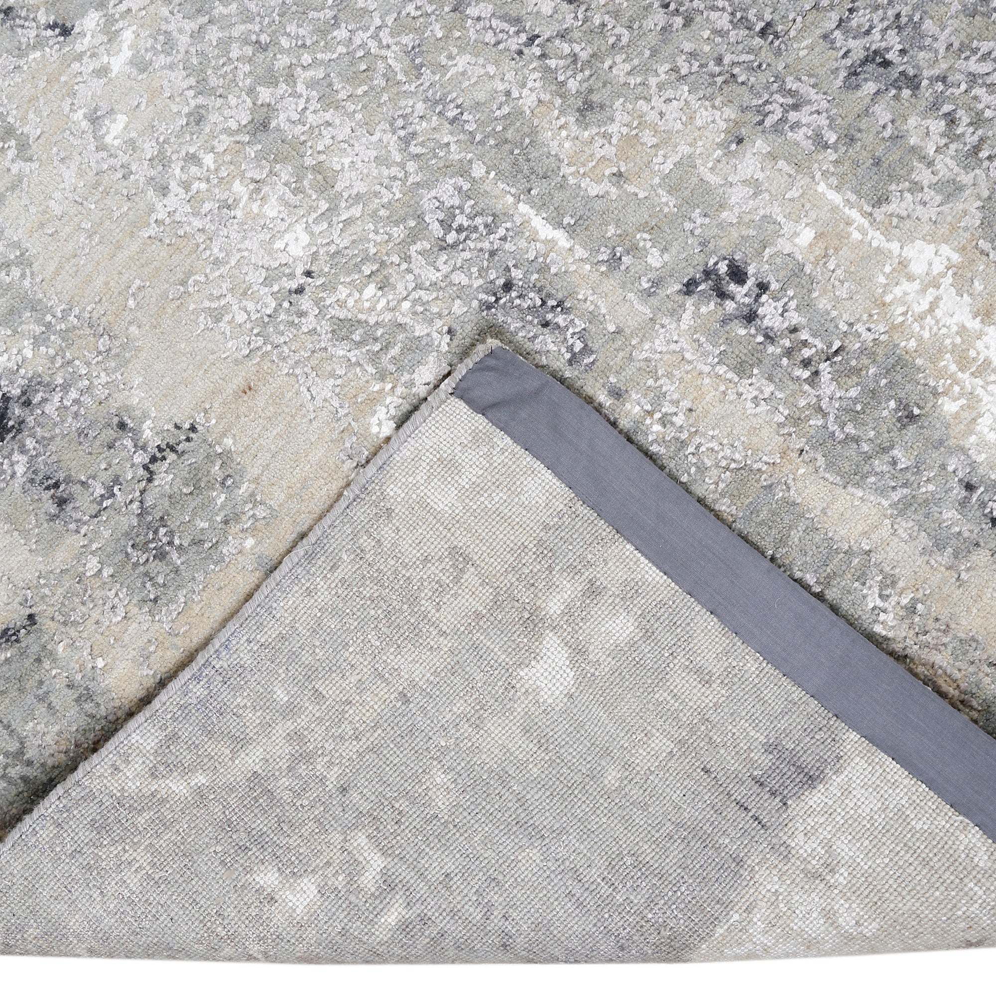 Hand-finished edge and softly distressed surface of the Glacier Whisper hand knotted modern rug