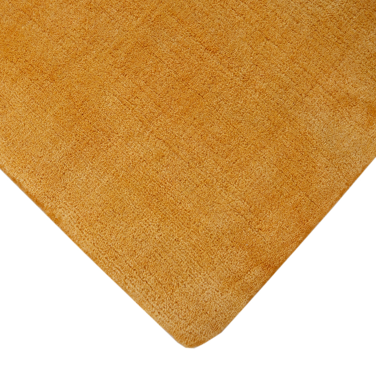 Corner and edge detail of gold hand woven Loom Lori wool rug showing its neat finishing, soft wool texture and plush 12–15 mm pile.