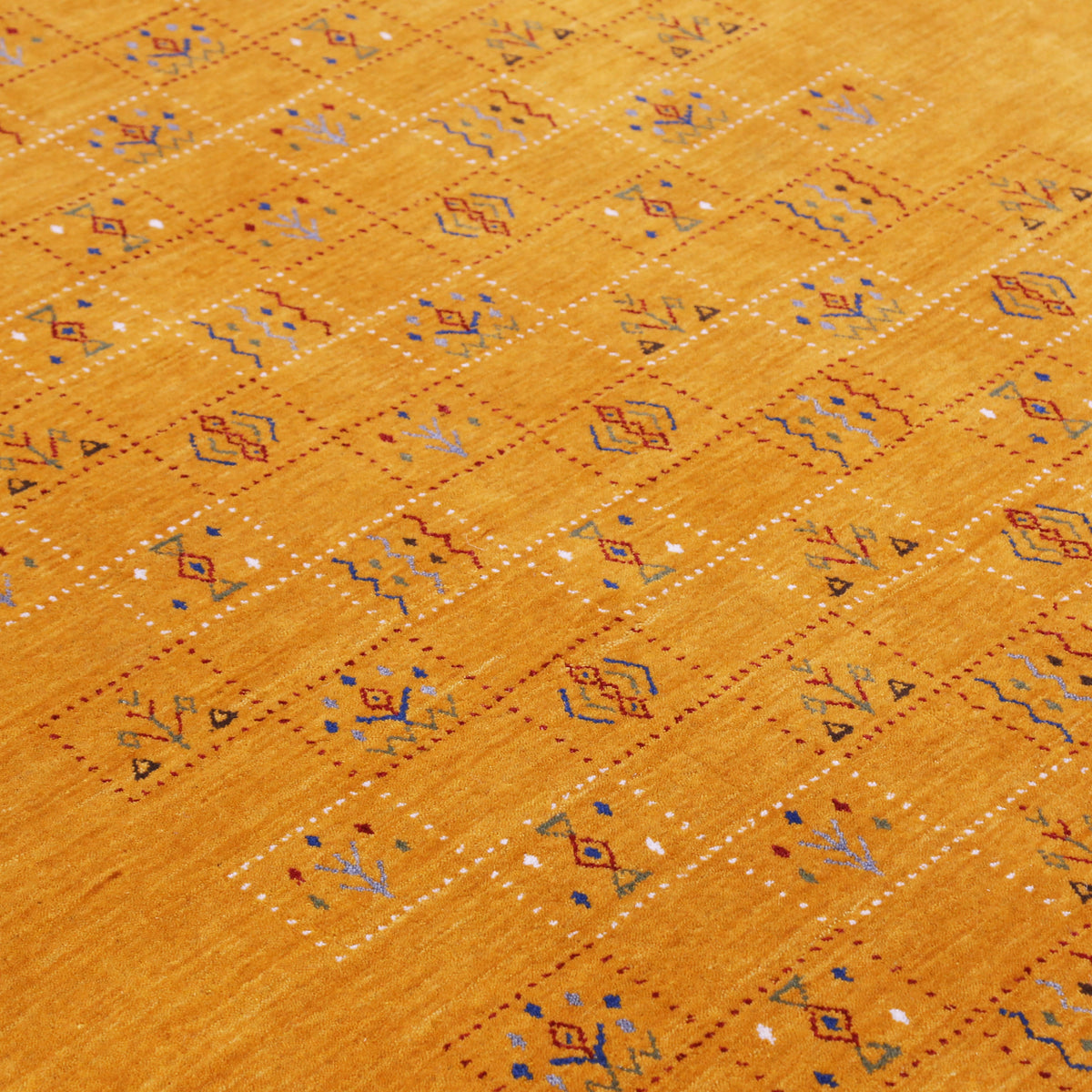 Close-up of golden mustard Hand Woven Loom Lori wool rug showing dotted geometric panels, botanical motifs and natural wool texture