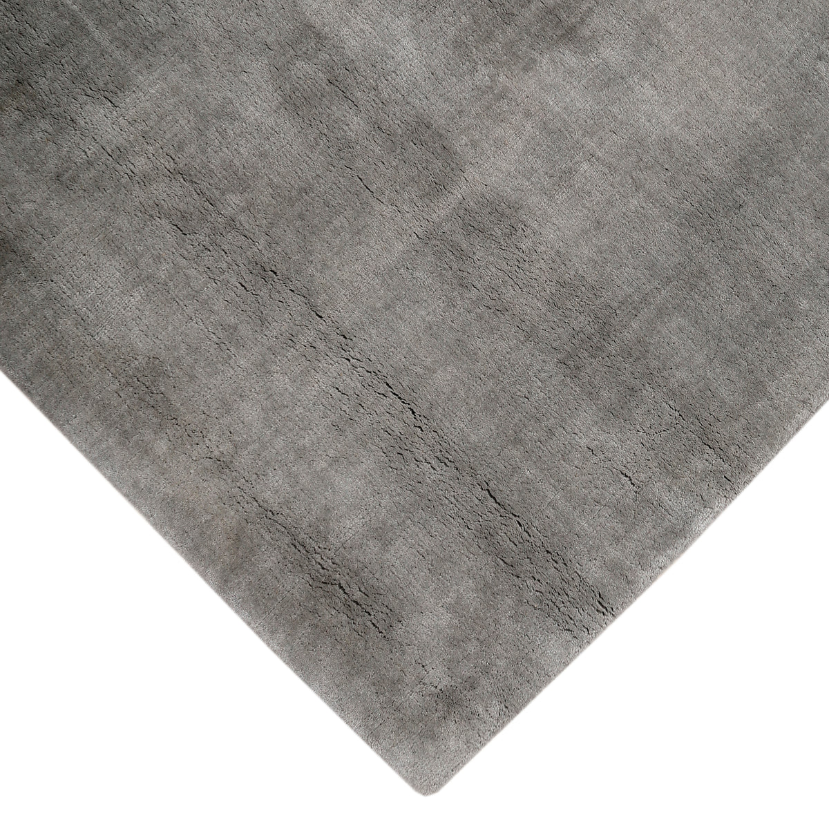 Corner and edge detail of grey hand woven Loom Lori wool rug showing its neat finishing, soft surface and plush 12–15 mm pile.