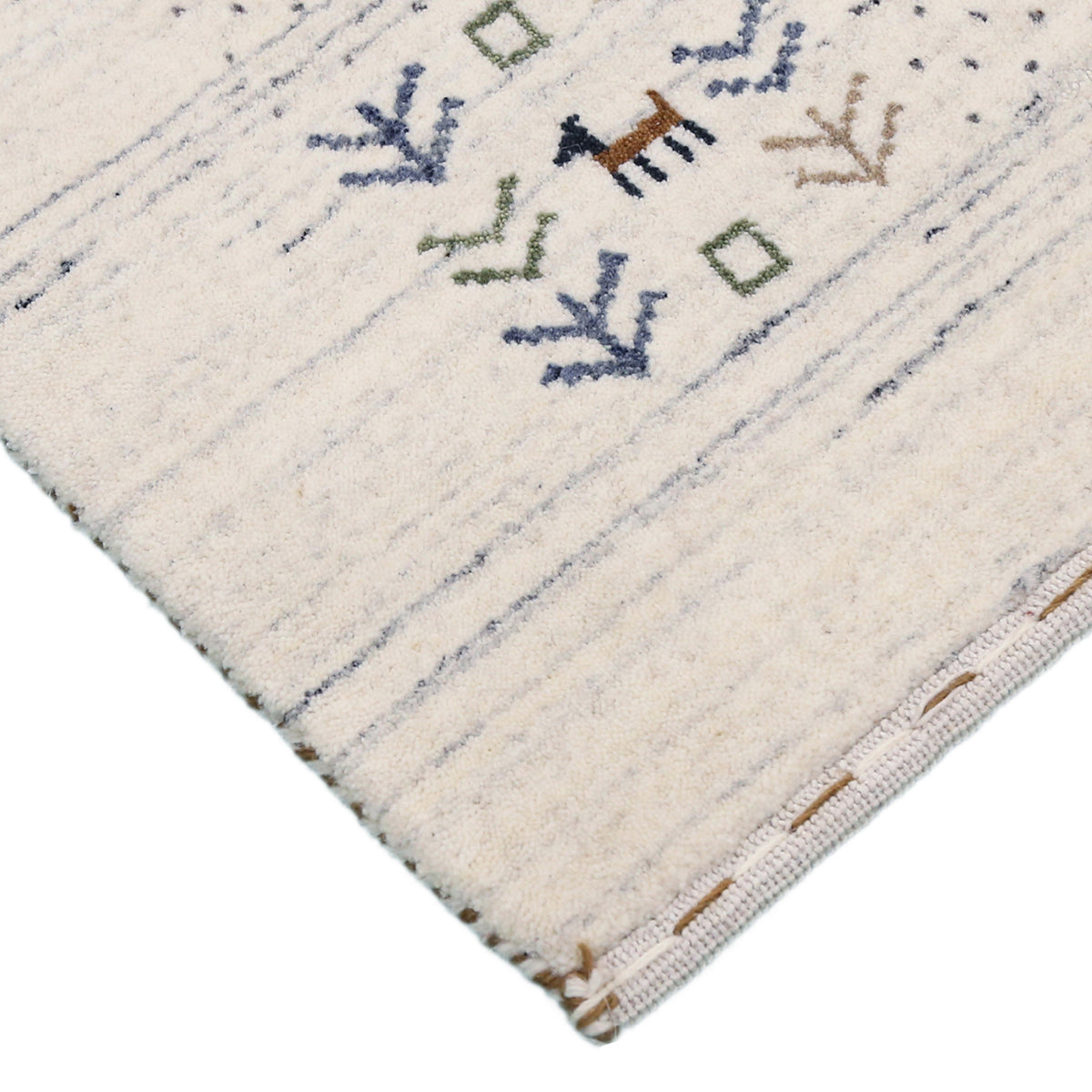 Corner and edge detail of ivory blue-grey Loom Lori wool rug showing dotted border, folk motifs and handcrafted finishing