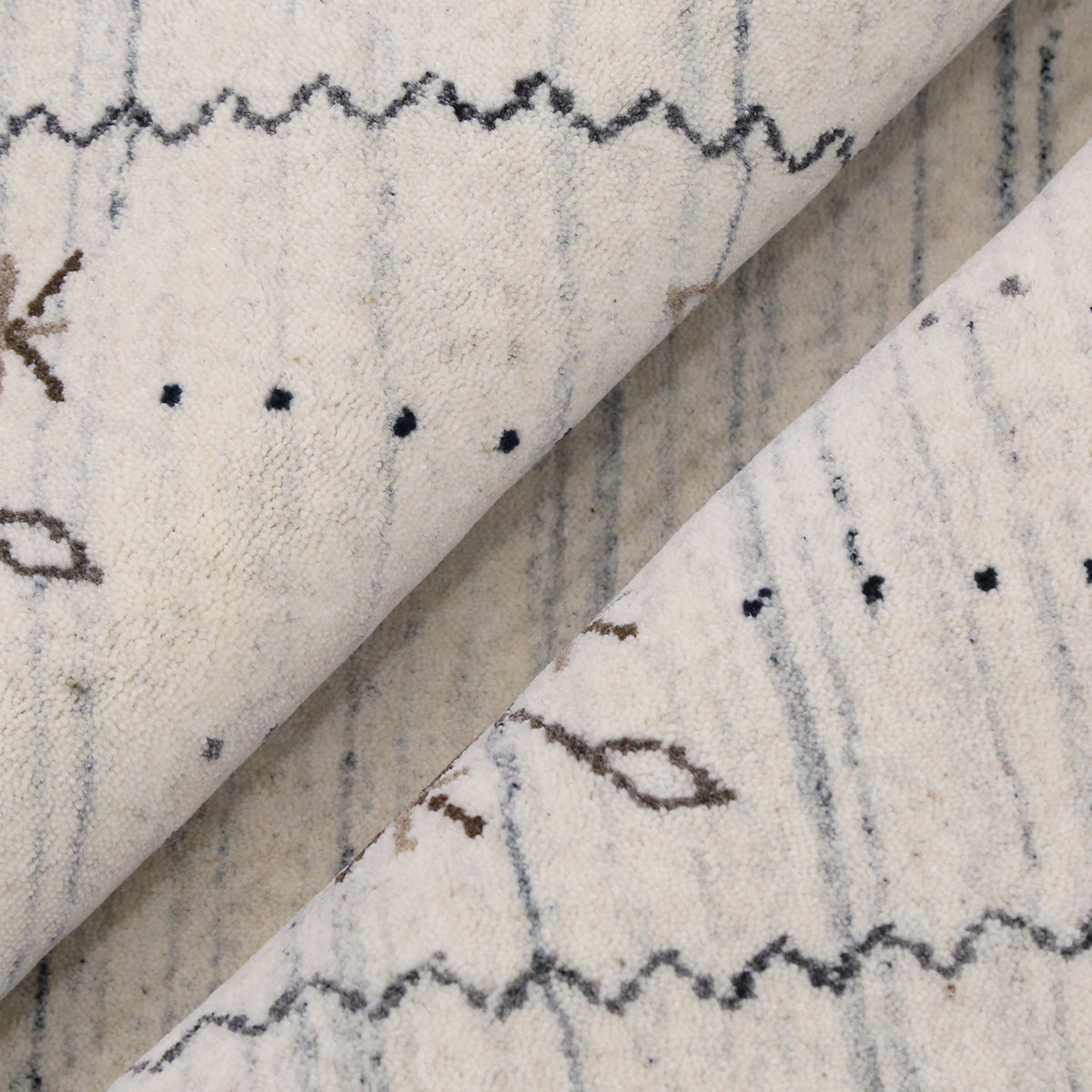 Close-up texture of ivory Hand Woven Loom Lori wool rug showing natural wool fibres, grey striations and subtle floral detailing