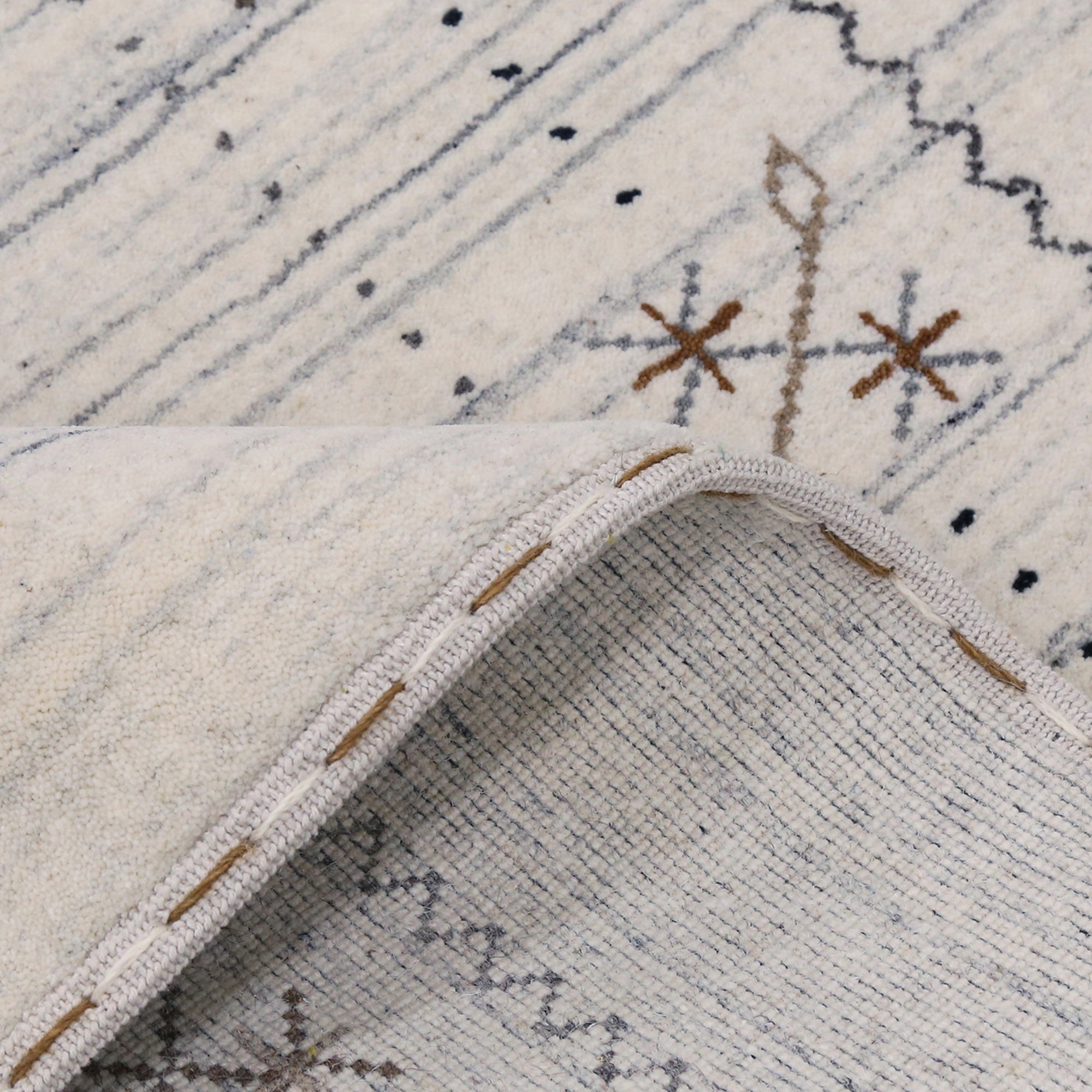 Corner and edge detail of ivory Hand Woven Loom Lori wool rug showing zigzag border and handcrafted finishing