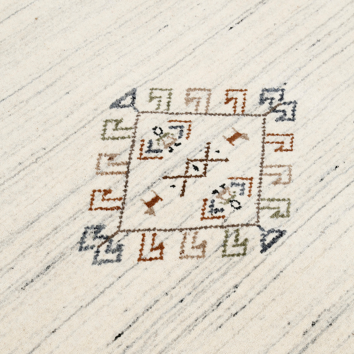 Close-up of ivory cream Hand Woven Loom Lori wool rug showing natural wool texture, grey striations and tribal geometric motifs