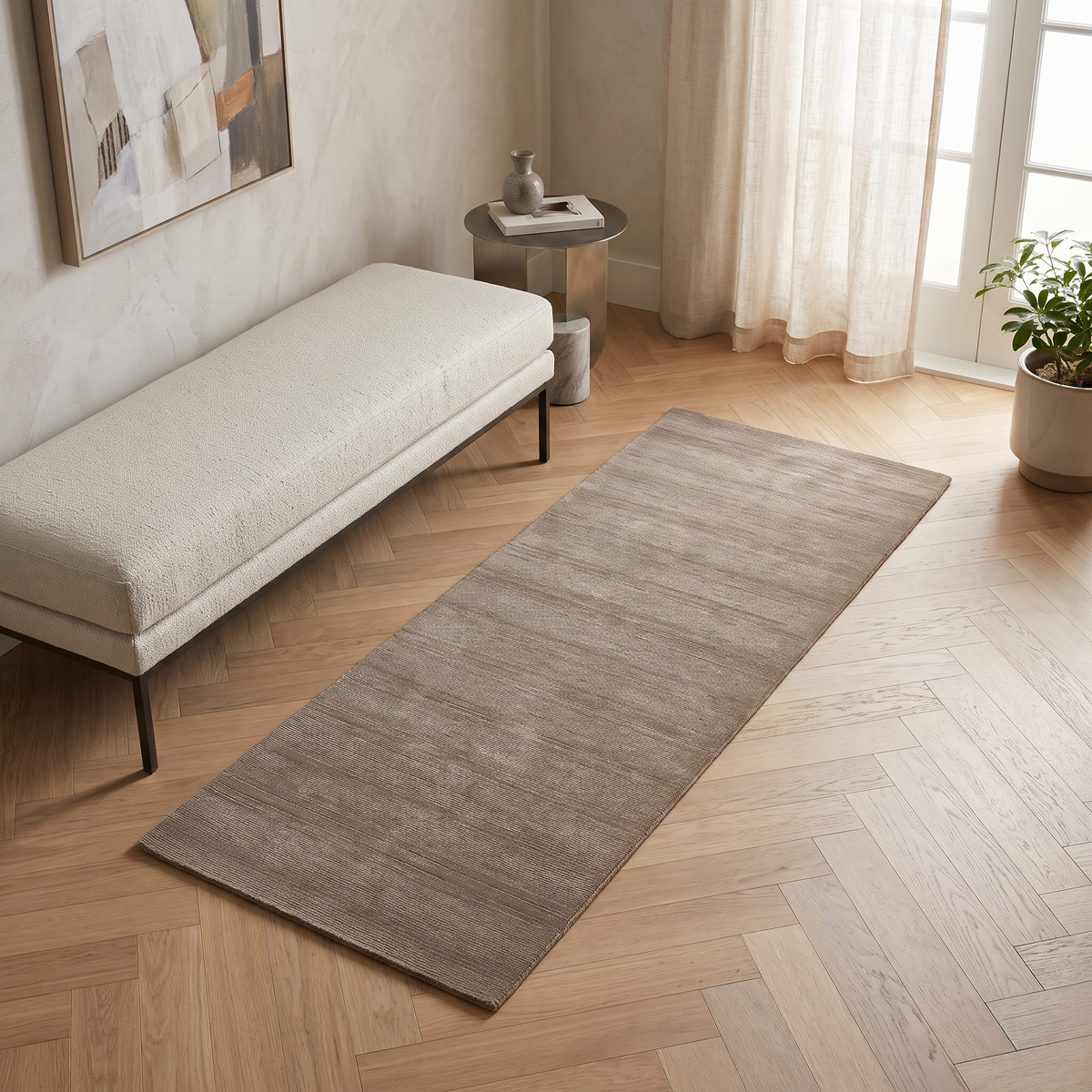 Light Beige Hand Woven Loom Lori wool rug styled in a modern interior beside a cream bench with warm wooden flooring and natural daylight.