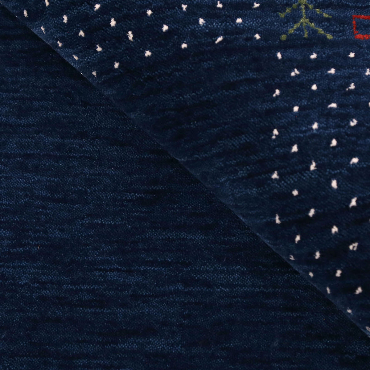 Close-up of navy blue Hand Woven Loom Lori wool rug showing natural wool texture, botanical symbols and colourful tribal motifs