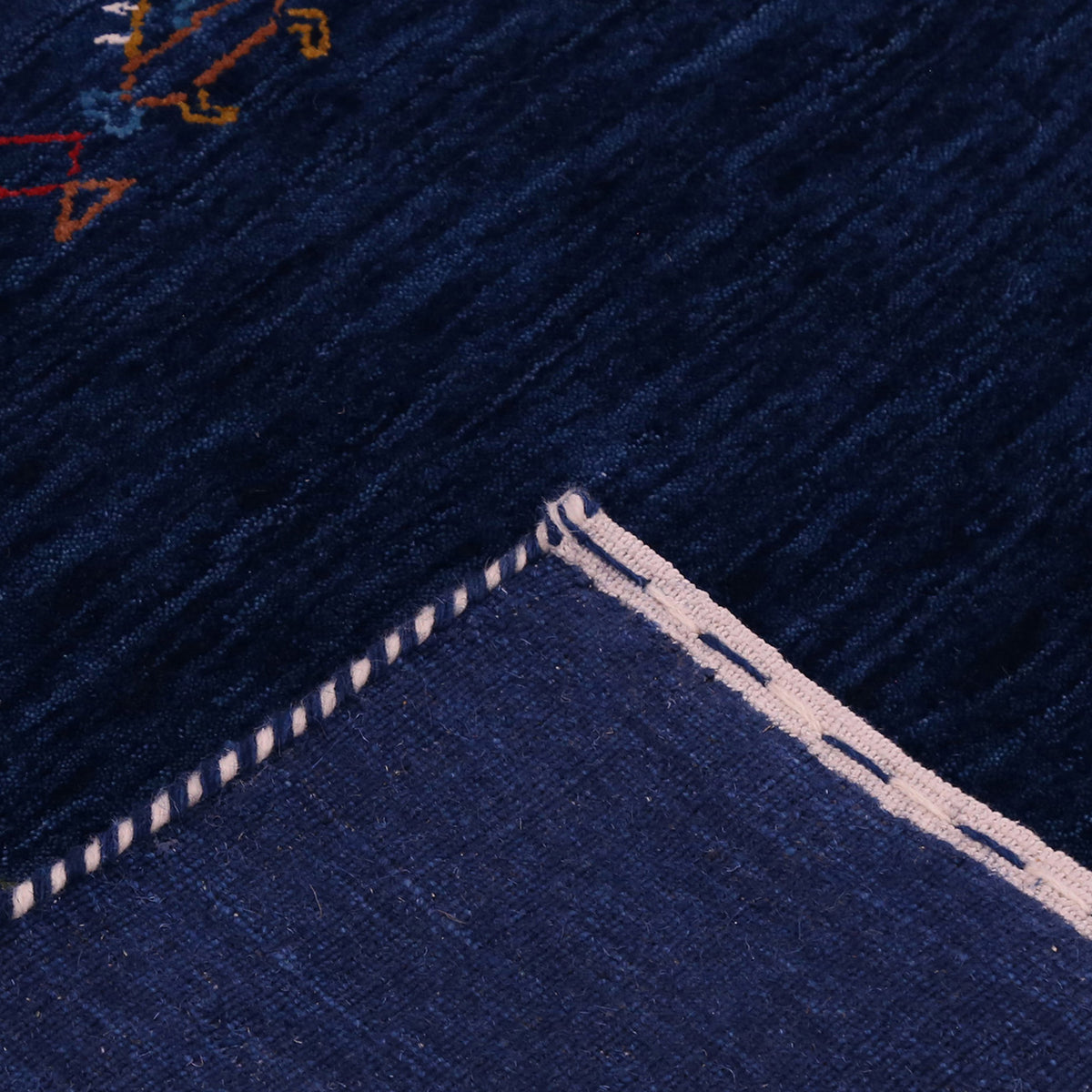 Corner and edge detail of navy Hand Woven Loom Lori wool rug showing geometric border motifs and handcrafted finishing