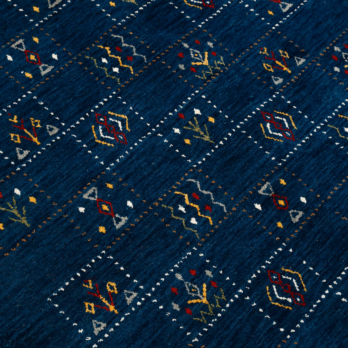 Close-up of deep navy blue Hand Woven Loom Lori wool rug showing dotted grid panels and multicolour tribal motifs
