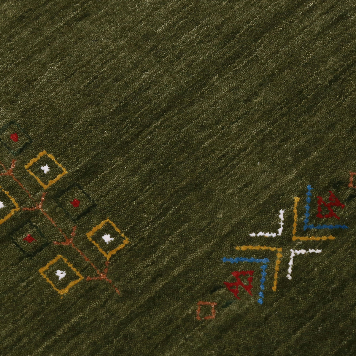 Close-up of olive green Hand Woven Loom Lori wool rug showing central diamond motif, colourful folk details and natural wool texture