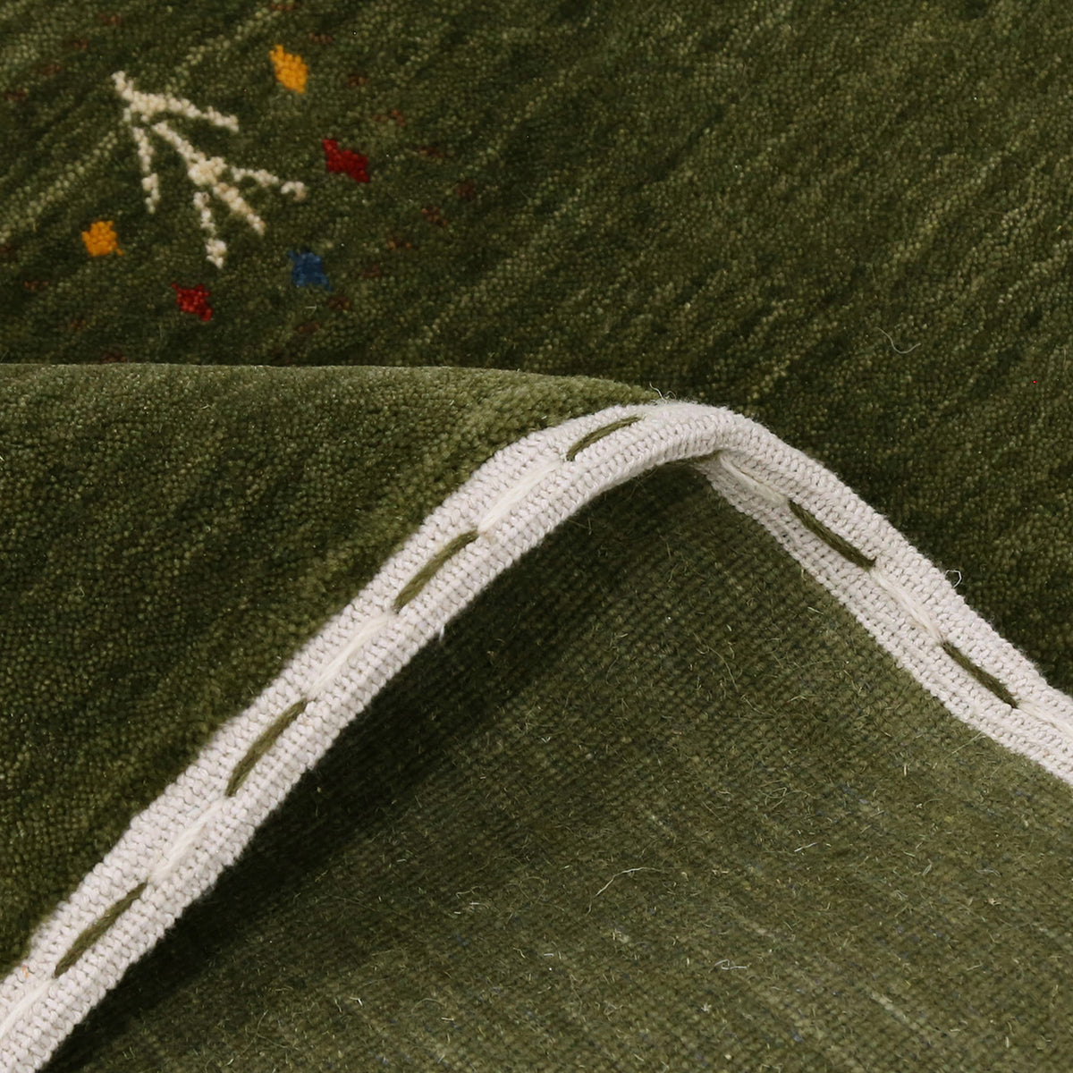 Close-up of olive green Hand Woven Loom Lori wool rug showing natural texture, framed geometric motifs and colourful tribal symbols
