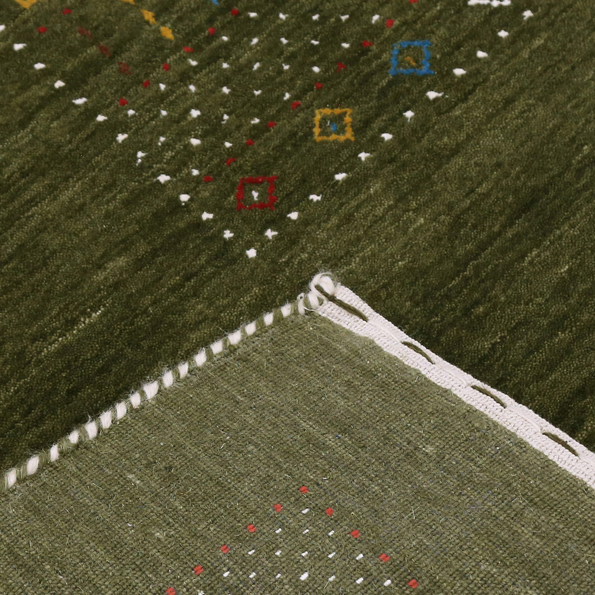 Corner and edge detail of olive green Hand Woven Loom Lori wool rug showing patterned border and handcrafted finish