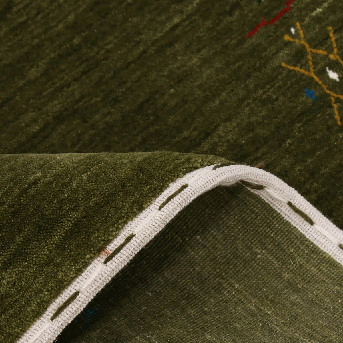 Close-up of olive green Hand Woven Loom Lori wool rug showing natural wool texture and detailed symbolic tribal motifs