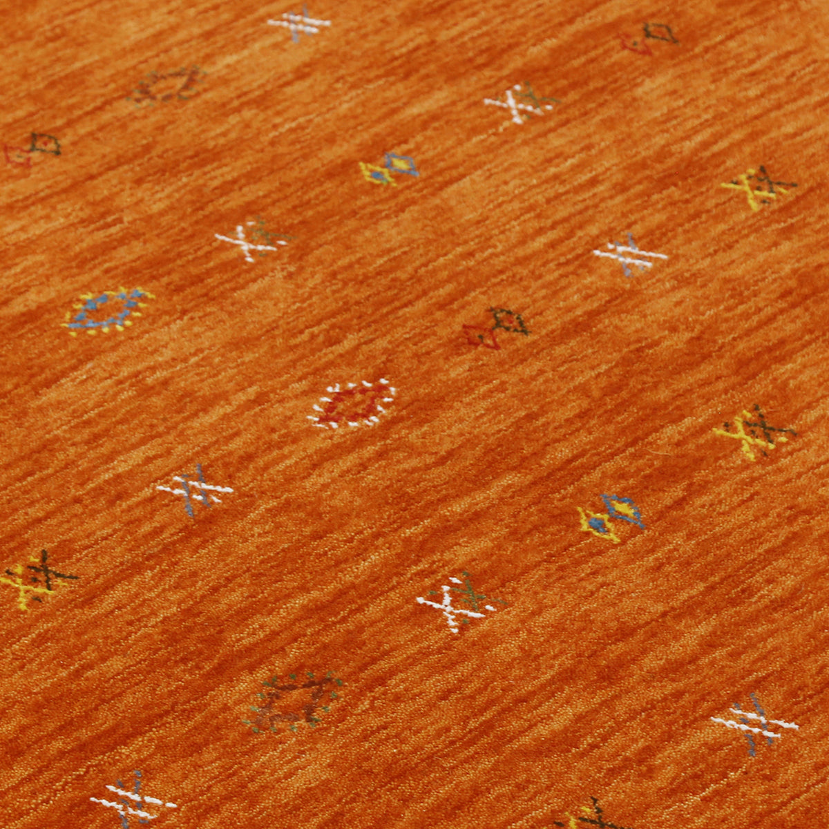 Close-up of terracotta orange Hand Woven Loom Lori wool rug showing natural wool texture and multicolour geometric motifs