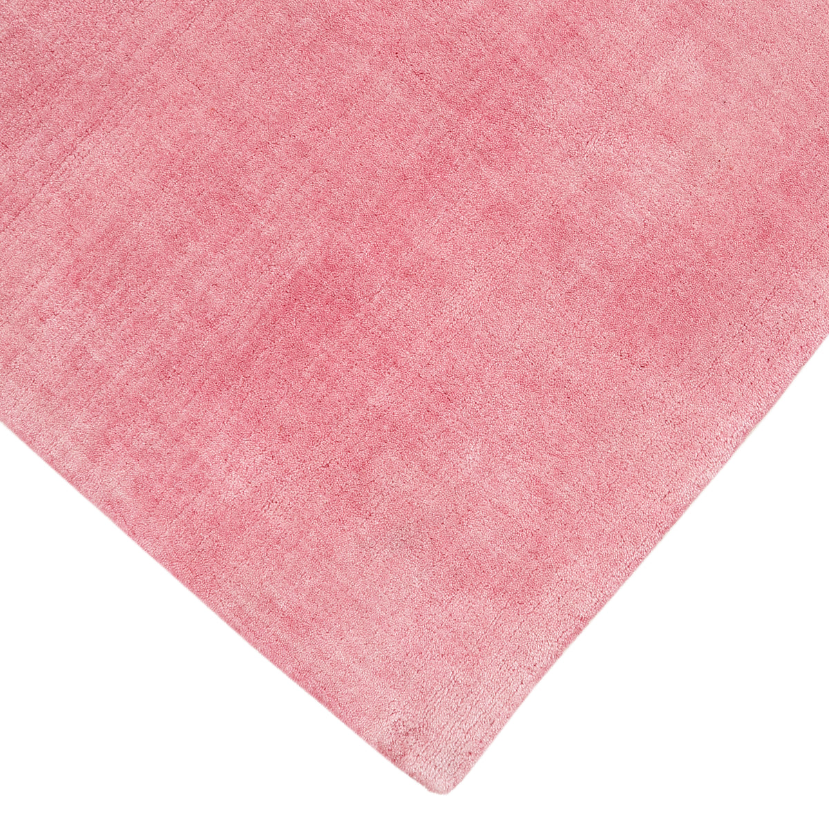 Corner and edge detail of pink hand woven Loom Lori wool rug showing its neat finishing, soft texture and plush 12-15 mm pile.