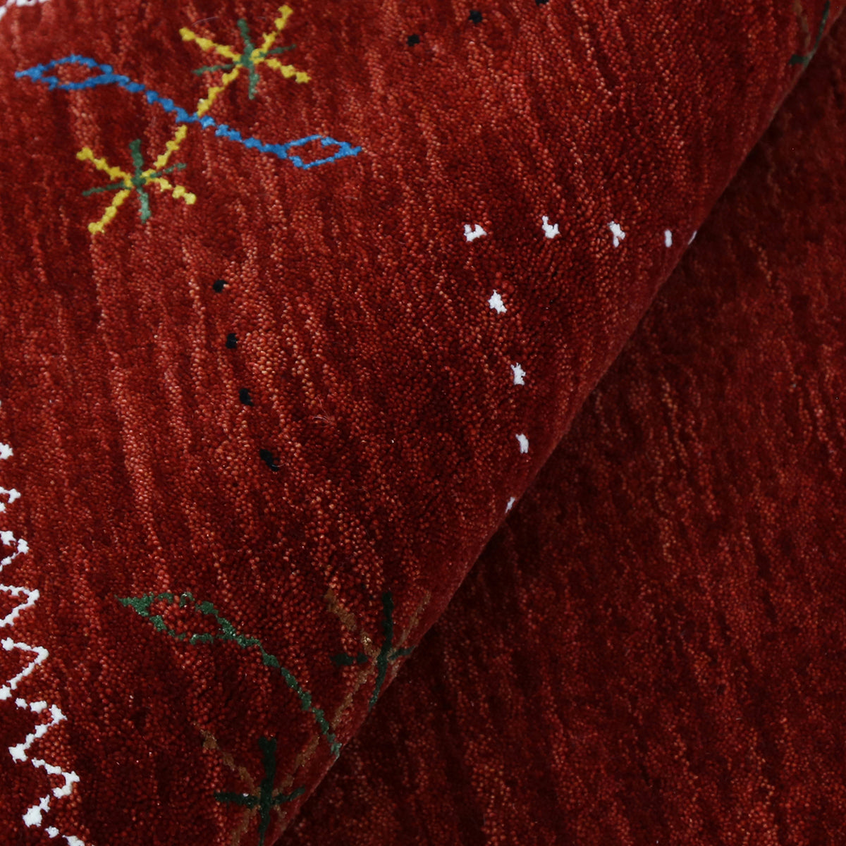 Close-up texture of red Hand Woven Loom Lori wool rug showing natural wool fibres and delicate multicolour floral detailing