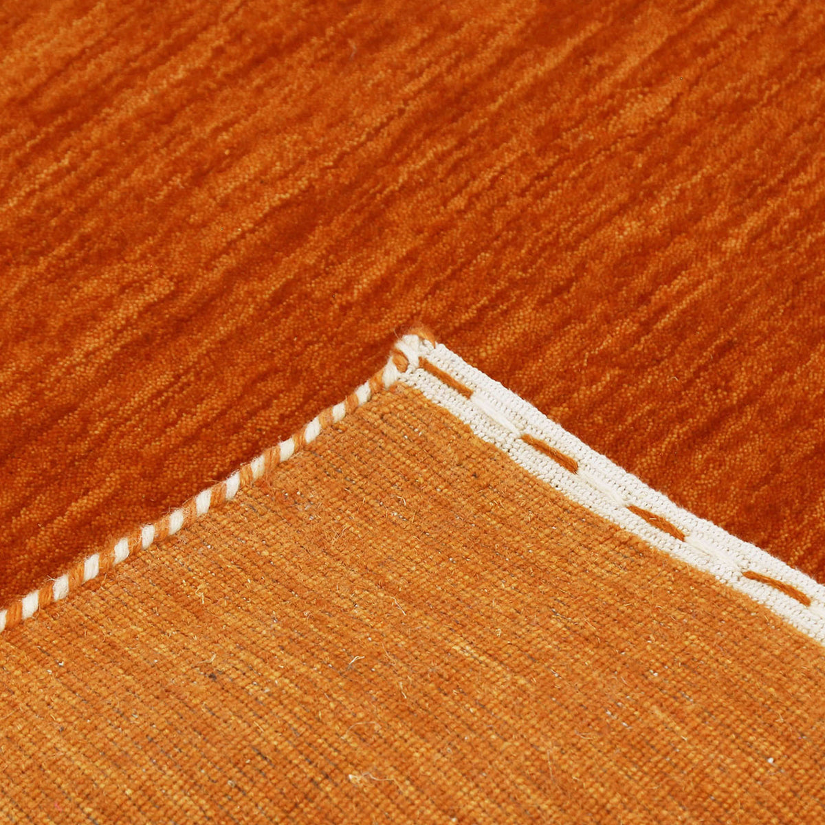 Corner and edge detail of rust orange Hand Woven Loom Lori wool rug showing handcrafted finish and geometric tribal motifs