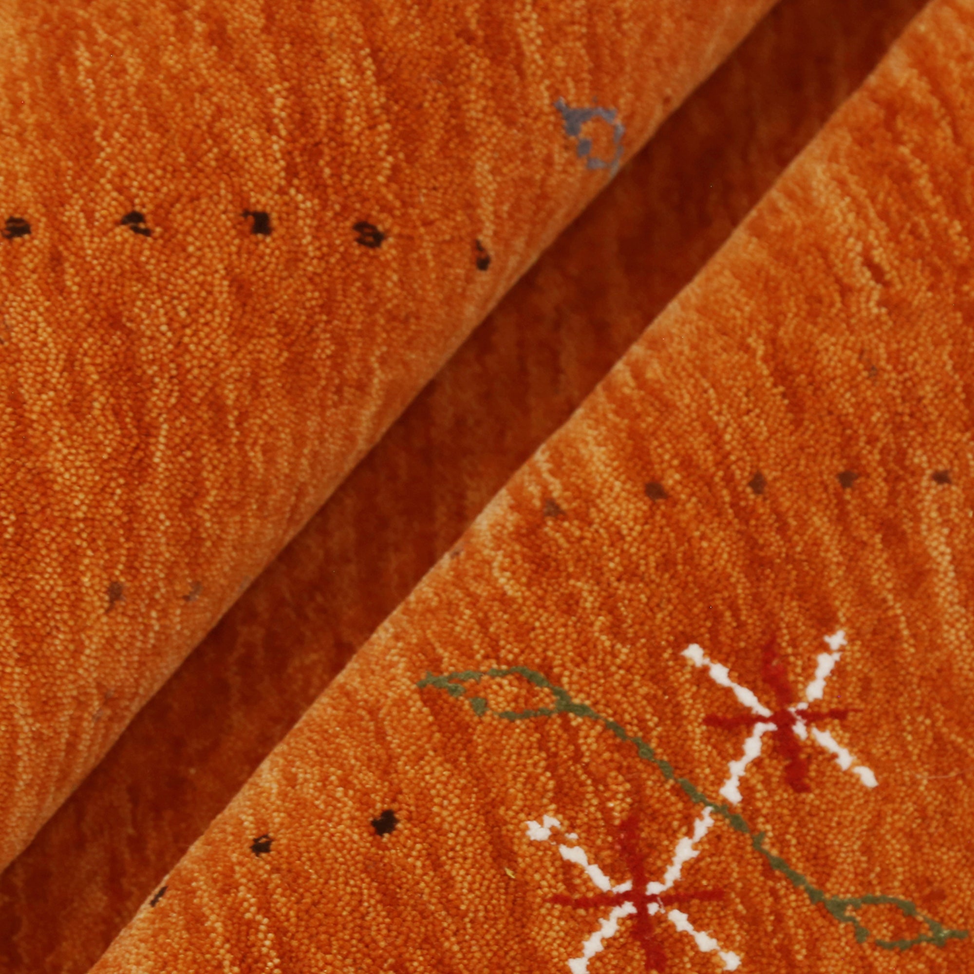 Close-up texture of rust orange Hand Woven Loom Lori wool rug showing natural wool fibres and delicate floral motif detailing