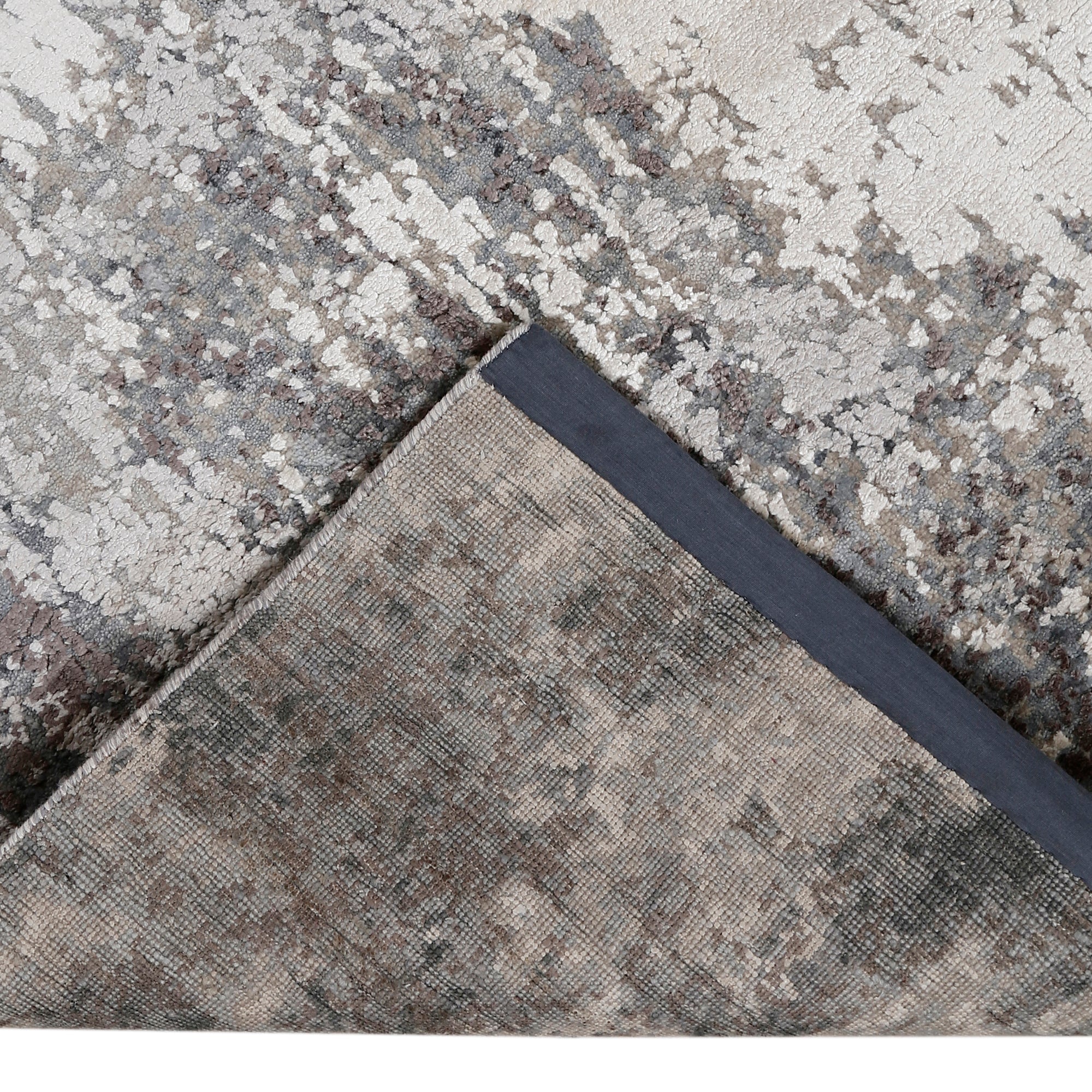 Hand-finished edge and layered distressed detailing of the silver ash abstract hand knotted rug