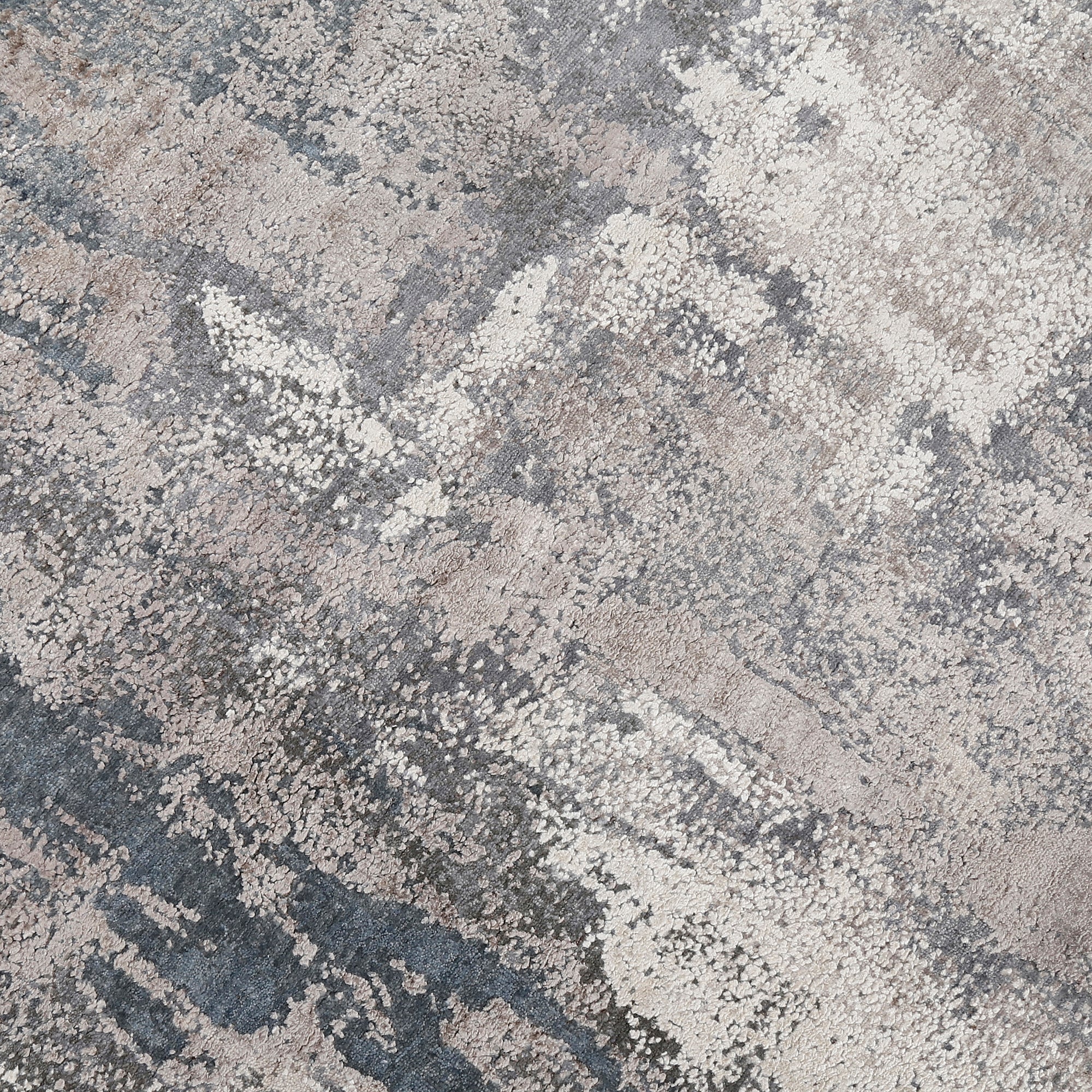 Close-up of the hand knotted wool and viscose texture with silver grey ivory beige and muted blue abstract detailing