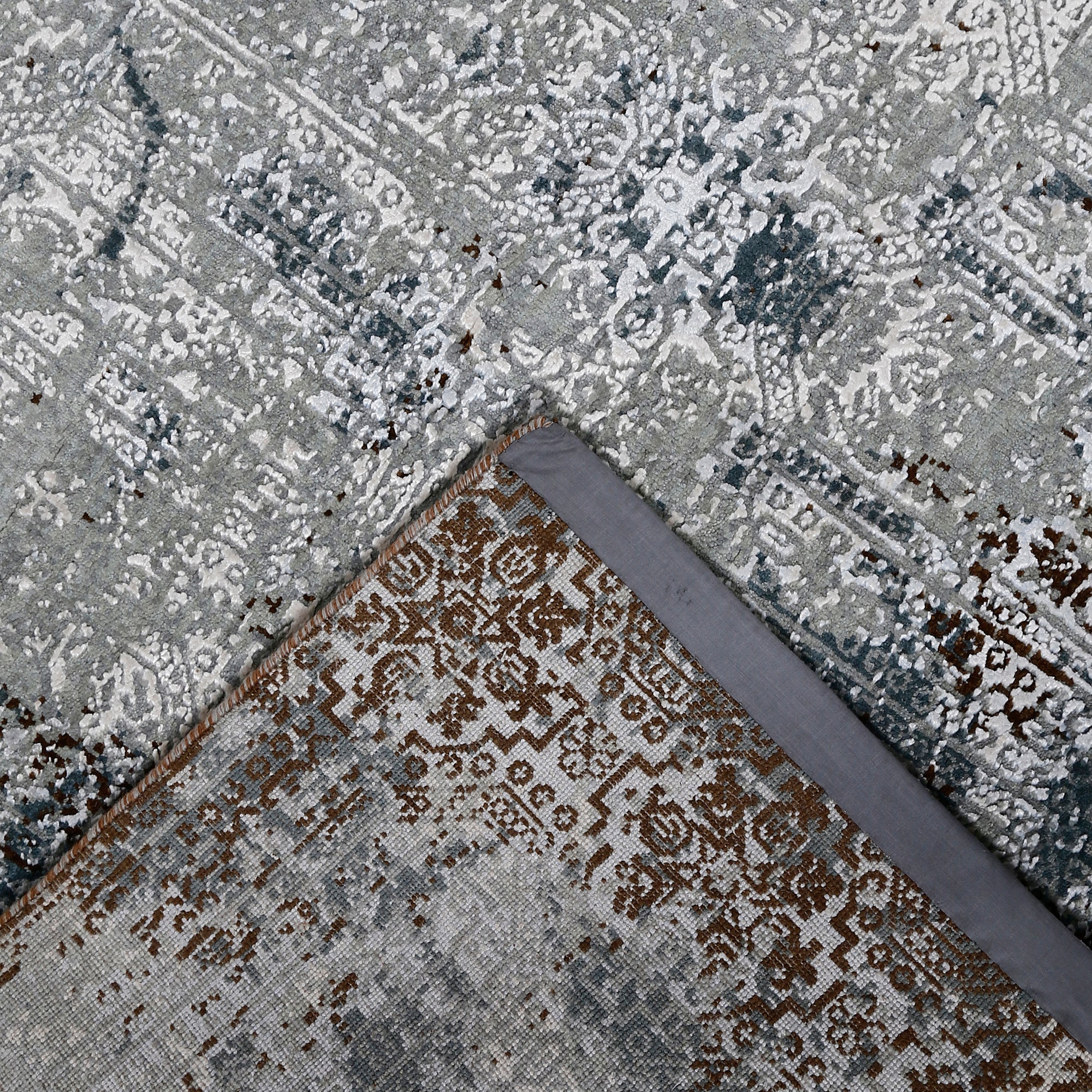 Hand-finished edge and layered distressed ornamental detailing of the silver slate hand knotted rug