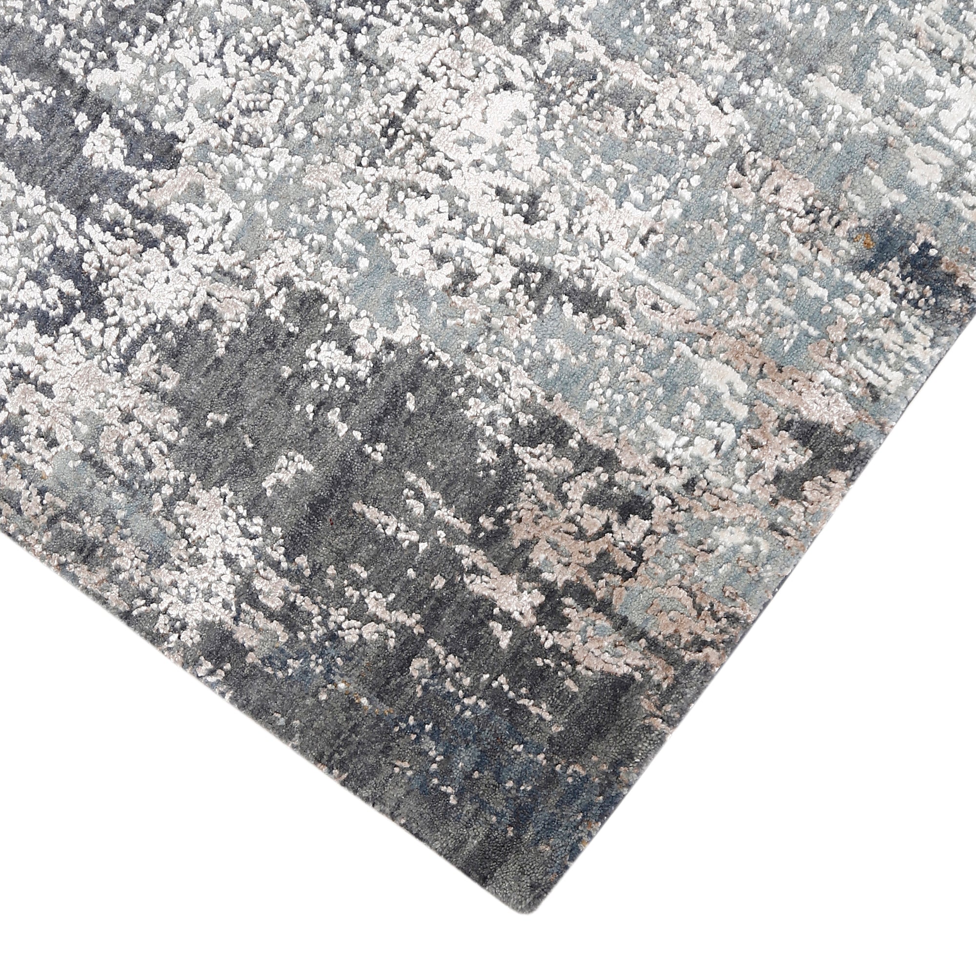 Hand-finished edge and layered distressed detailing of the silver taupe abstract hand knotted rug