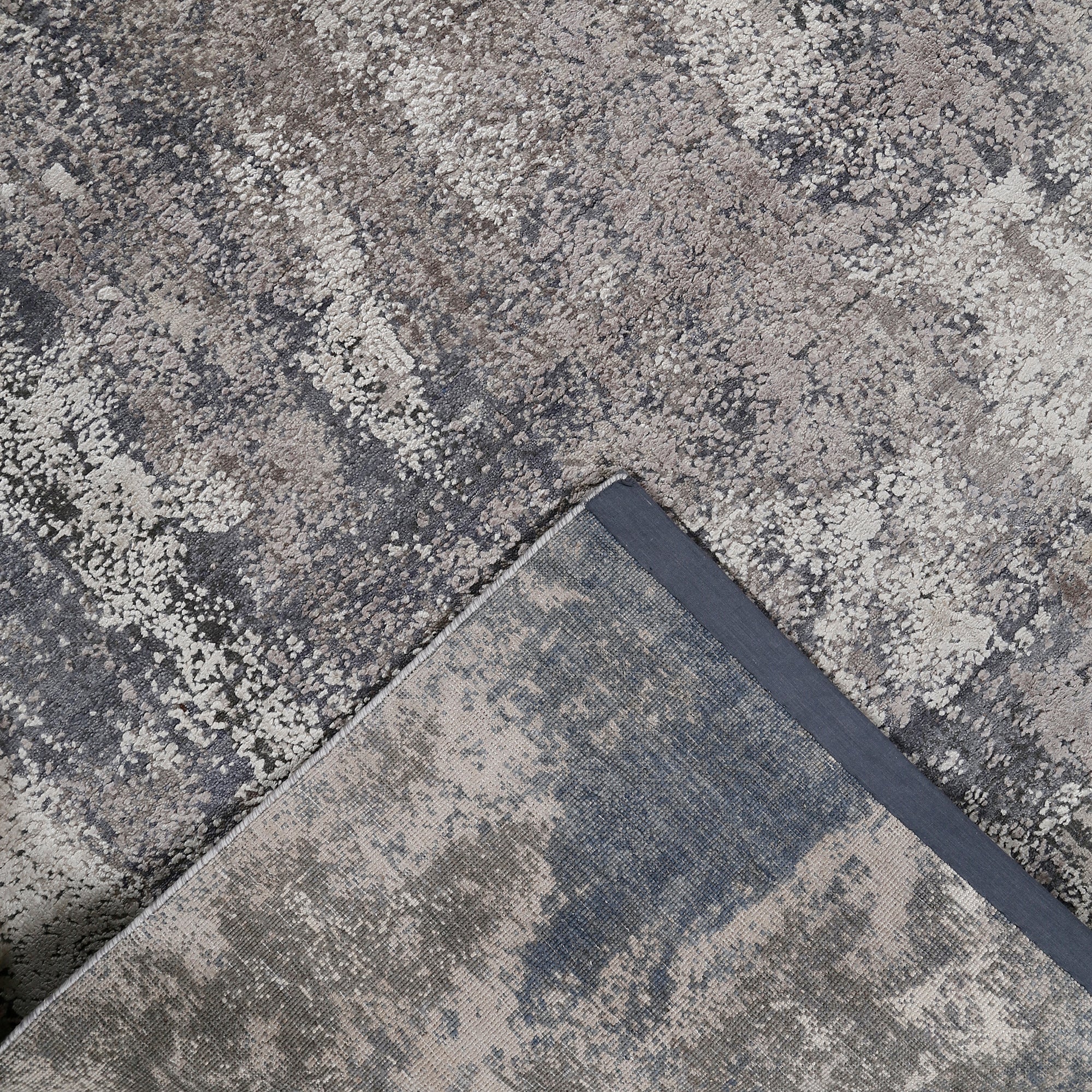Hand-finished edge and textured abstract surface of the Silvermist Cascade hand knotted modern rug