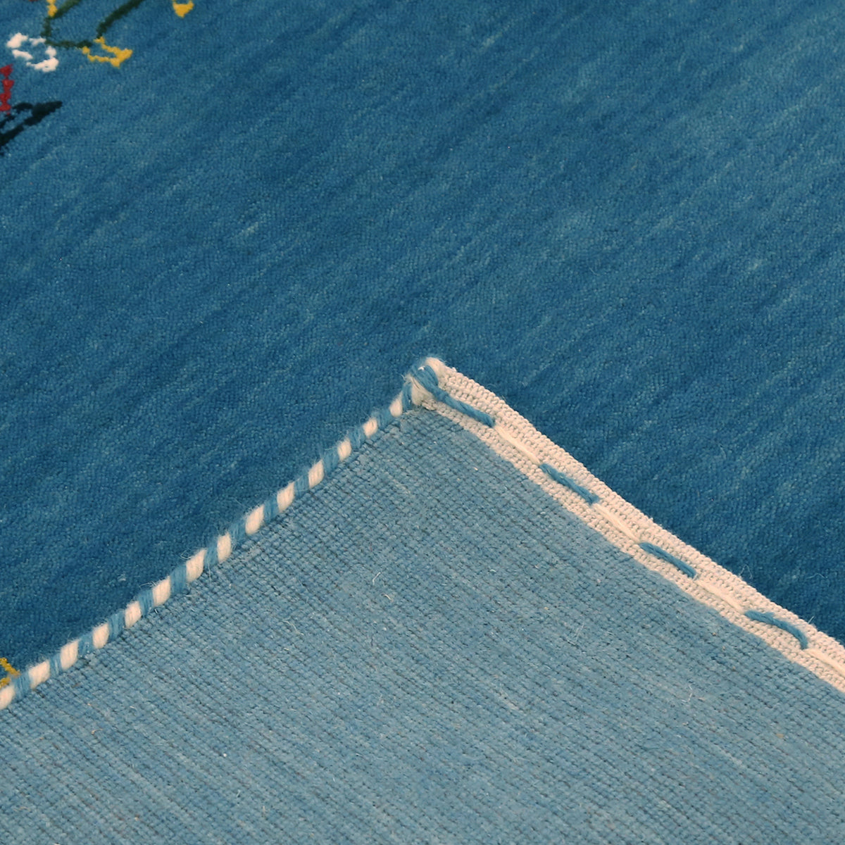 Corner and edge detail of sky blue Hand Woven Loom Lori wool rug showing handcrafted finishing and geometric motifs