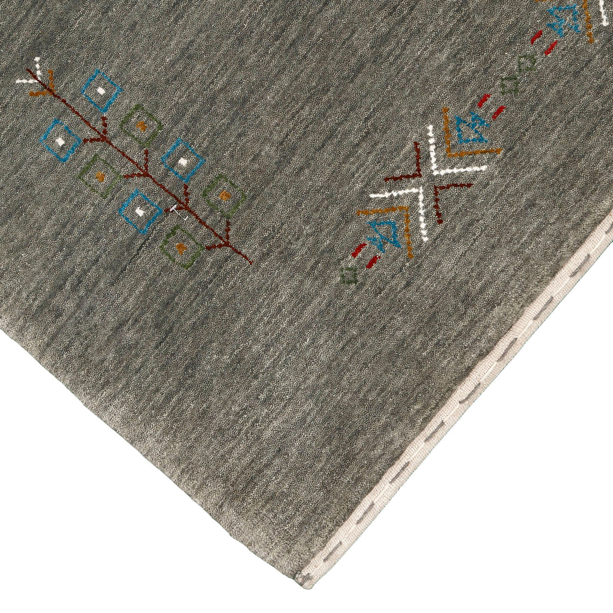 Corner and edge detail of olive grey Hand Woven Loom Lori wool rug showing handcrafted finishing and geometric tribal motifs