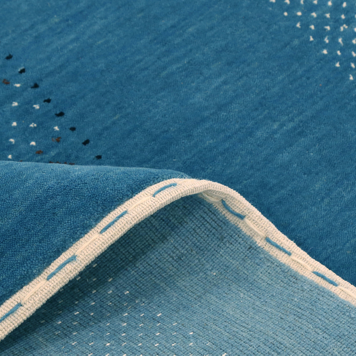 Close-up texture of teal blue Hand Woven Loom Lori wool rug showing natural wool fibres and geometric motif detailing