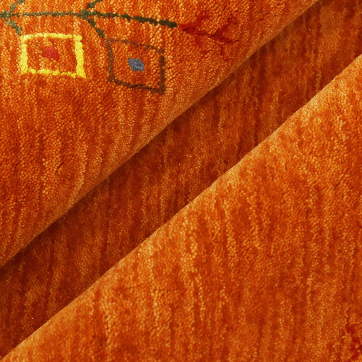 Close-up of rust orange Hand Woven Loom Lori wool rug showing central diamond motif, colourful folk details and natural wool texture