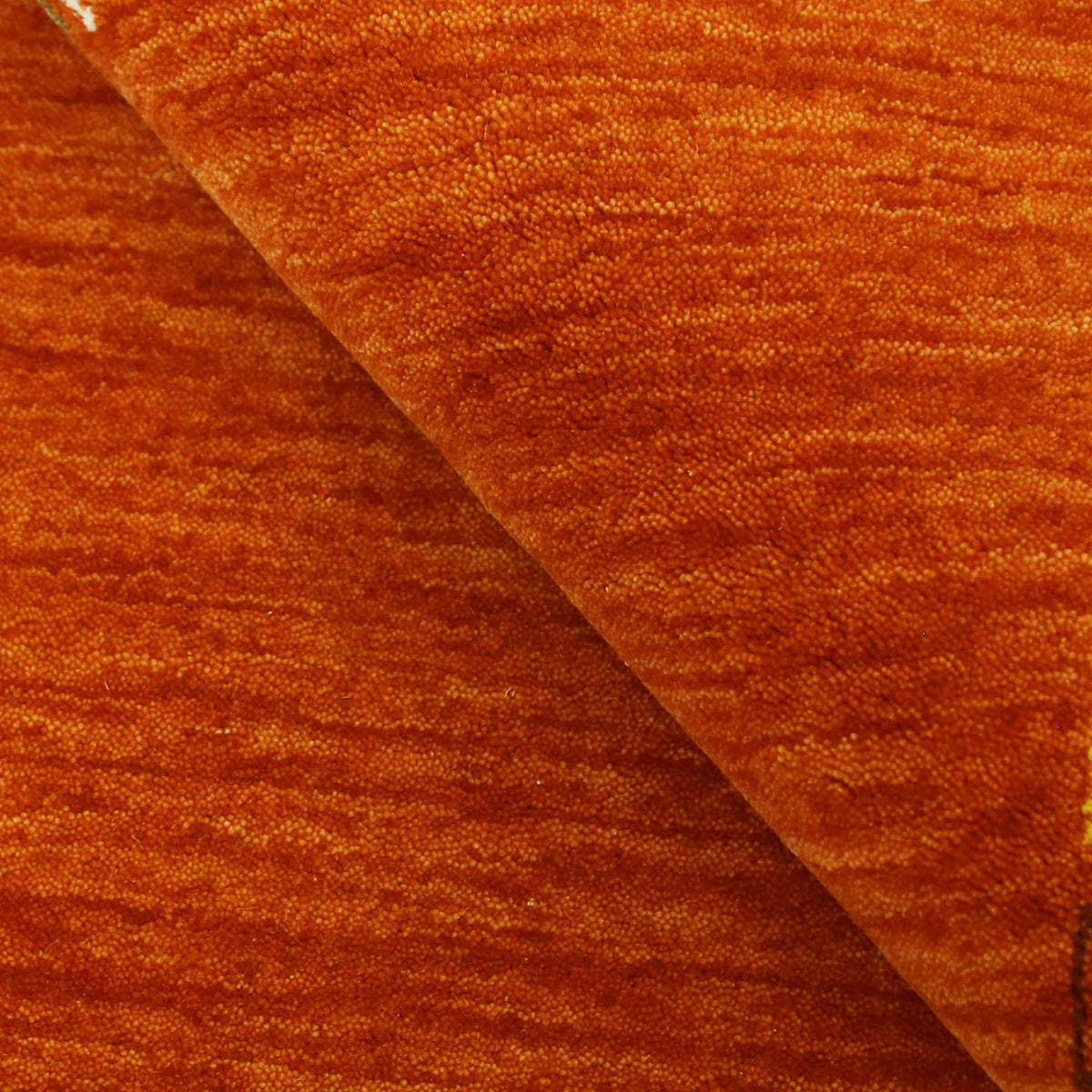 Close-up of rust orange Hand Woven Loom Lori wool rug showing central diamond motif, colourful folk details and natural wool texture