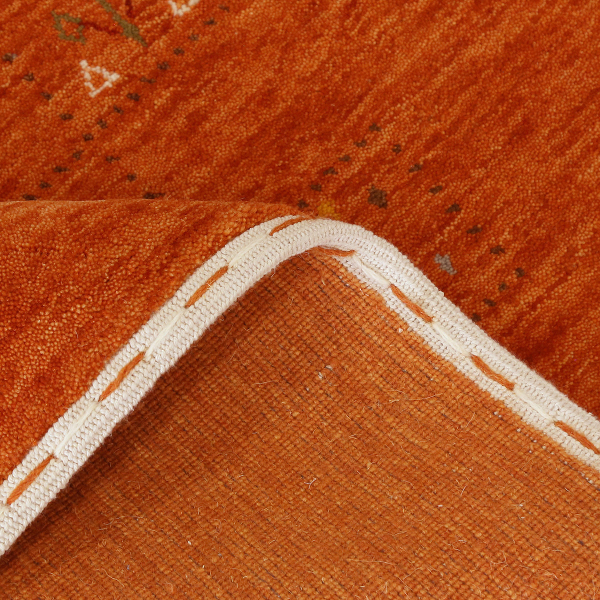 Close-up of burnt orange Hand Woven Loom Lori wool rug showing natural wool texture and multicolour tribal geometric motifs