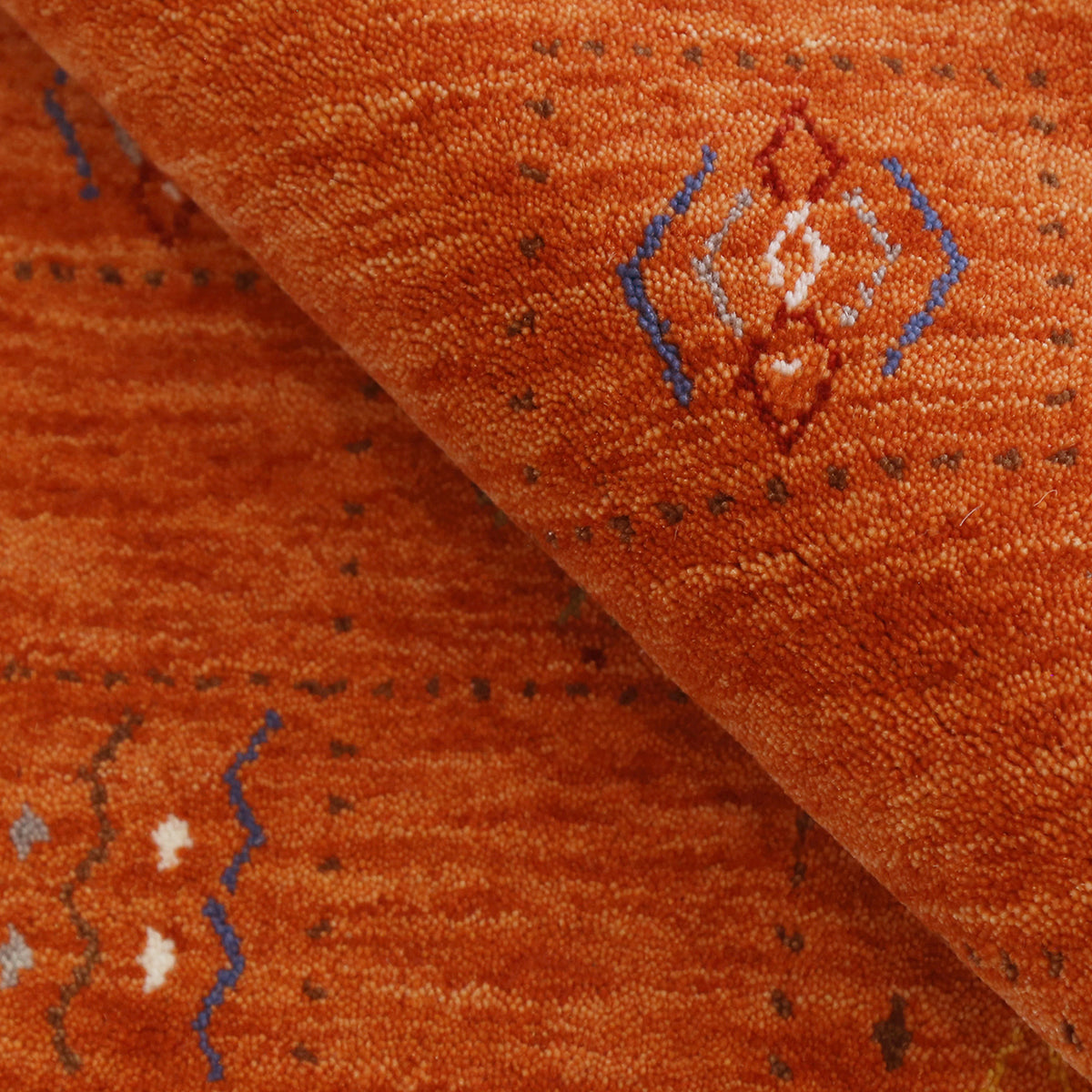 Close-up of burnt orange Hand Woven Loom Lori wool rug showing natural wool texture and multicolour tribal geometric motifs