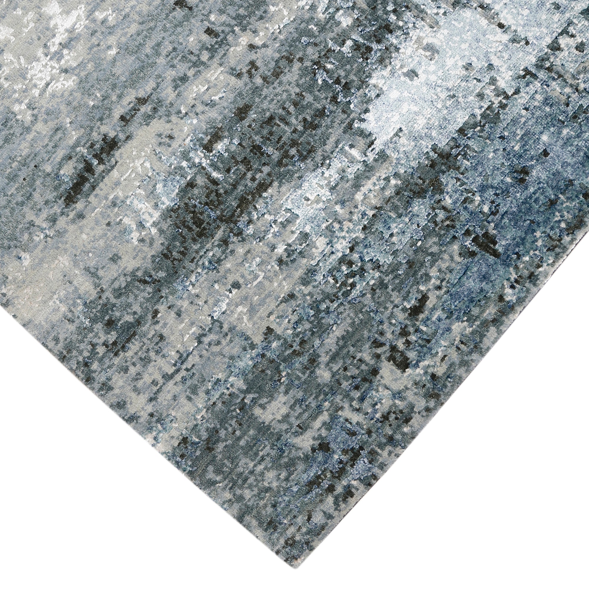Hand-finished edge and horizontally distressed surface of the Arctic Drift hand knotted modern rug