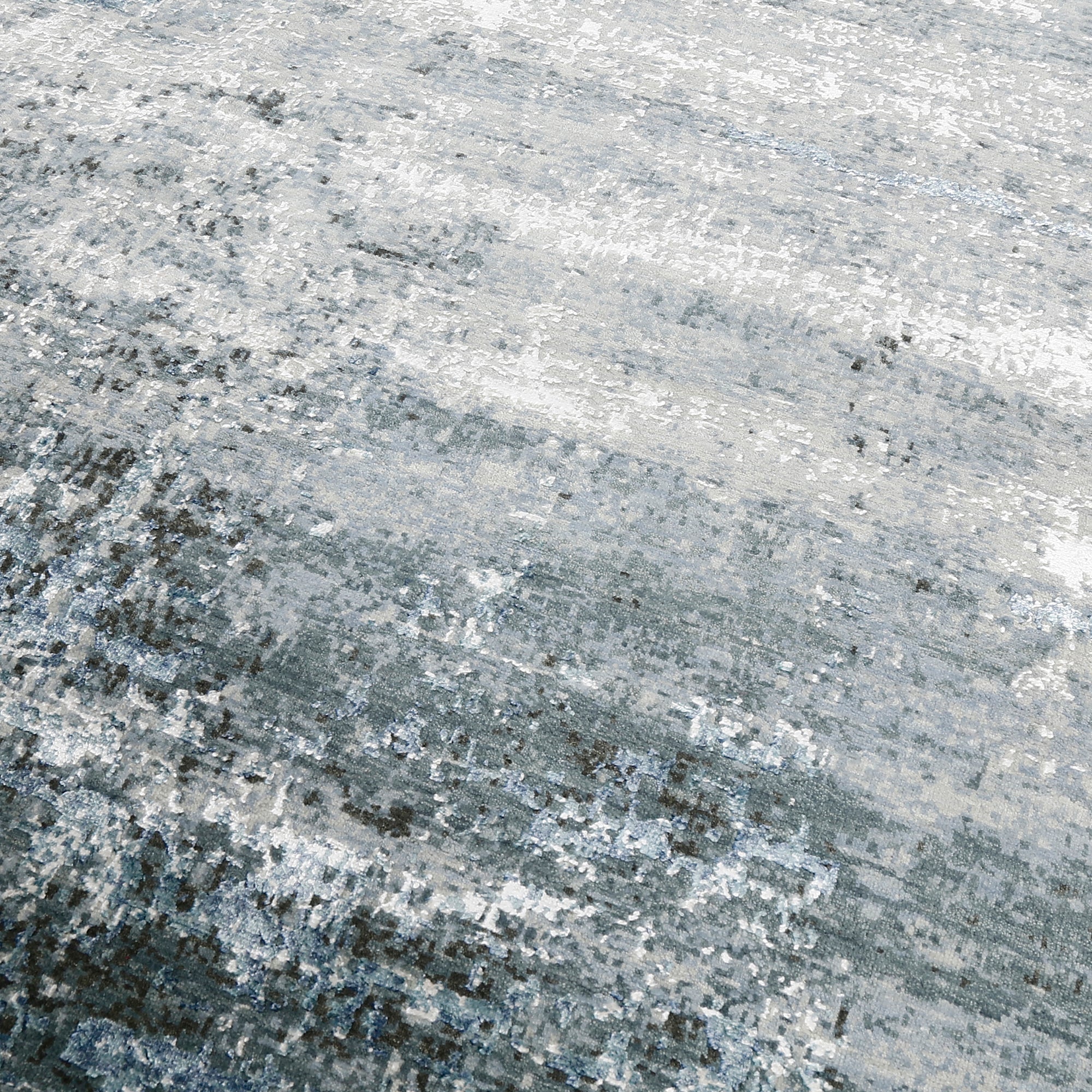 Close-up of the hand knotted wool and viscose texture with silver grey ivory and icy blue abstract detailing