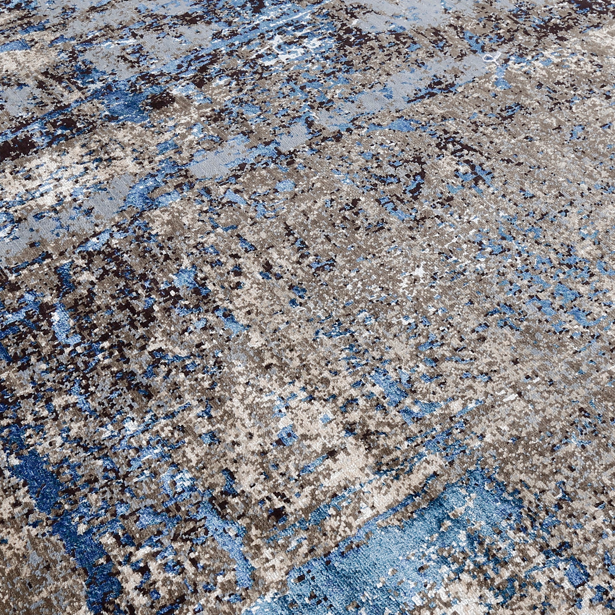 Close-up of the hand knotted wool and viscose texture with beige grey brown and sky blue abstract detailing