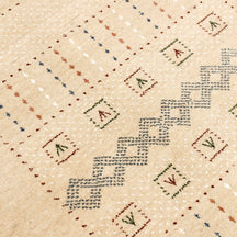 Close-up of natural beige Hand Woven Loom Lori wool rug showing wool texture, interlocking diamond motifs and tribal detailing