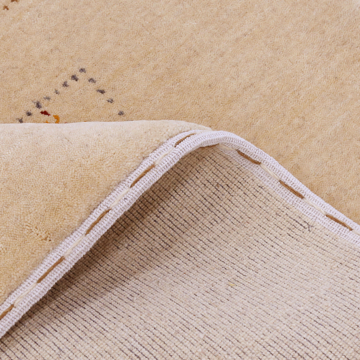 Close-up of warm beige Hand Woven Loom Lori wool rug showing dotted grid panels, diamond motifs and natural wool texture
