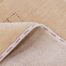 Close-up of warm beige Hand Woven Loom Lori wool rug showing dotted grid panels, diamond motifs and natural wool texture