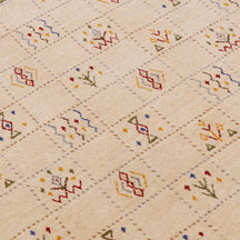 Close-up of warm beige Hand Woven Loom Lori wool rug showing dotted grid panels, diamond motifs and natural wool texture