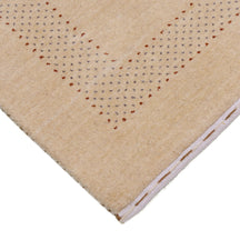 Corner and edge detail of beige Hand Woven Loom Lori wool rug showing patterned border and handcrafted finishing