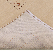 Corner and edge detail of beige Hand Woven Loom Lori wool rug showing patterned border and handcrafted finishing