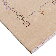 Corner and edge detail of natural beige Loom Lori wool rug showing geometric motifs and traditional handcrafted finishing
